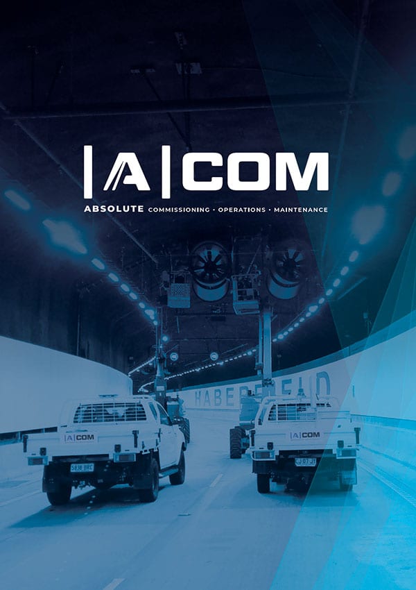 Promotional image for IACOM featuring two utility vehicles exiting a tunnel, with the company's acronym and services printed above.