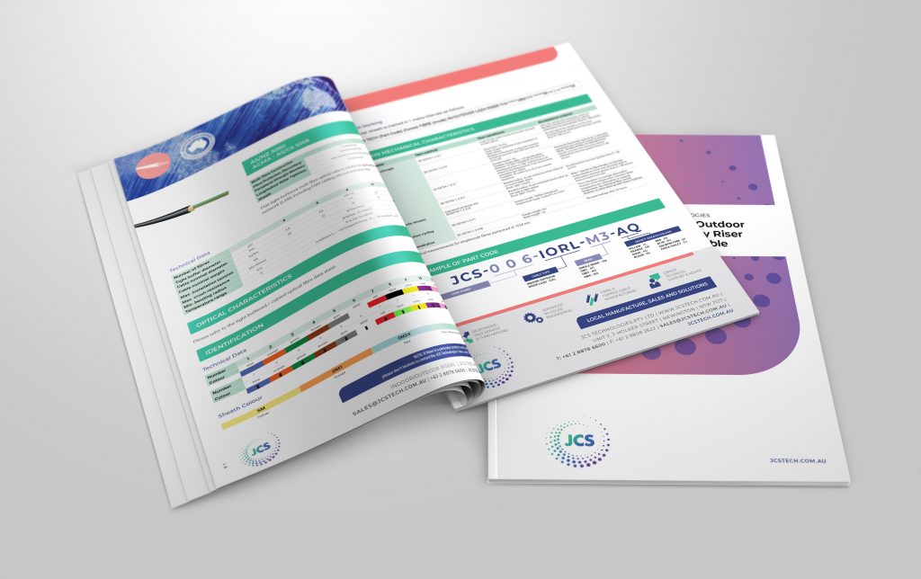 Two open booklets displaying colorful charts, data tables, and text content alongside a closed booklet with a purple and white cover, all exemplifying expert catalogue design to promote JCS.