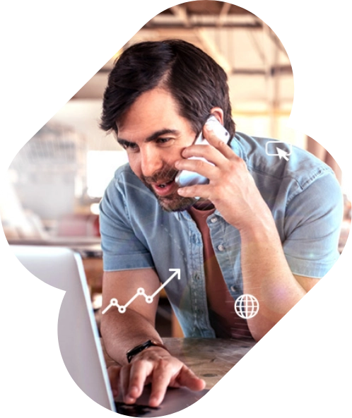 A man with dark hair and beard is sitting at a desk, talking on the phone, and using a laptop. Icons of a graph, refresh symbol, and globe are overlaid on the image, suggesting he might be managing pay per click campaigns.