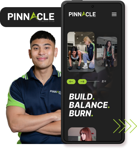 A person in a 'Pinnacle Fitness Club' polo stands next to a phone displaying the club's app interface, which shows images of people working out and the phrases "Build. Balance. Burn." It's the perfect time to revamp your website with our dynamic fitness content to attract new clients.