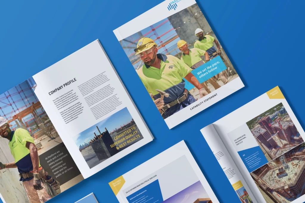 Open brochure layout featuring a construction company profile with images of workers on site and text sections on company details, laid on a blue background.