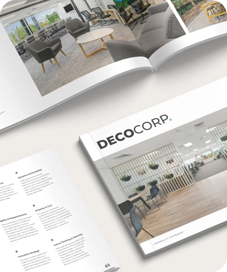 Open magazine featuring elegant interior design layouts with the title "decocorp." on the visible page, displaying modern office and living spaces.