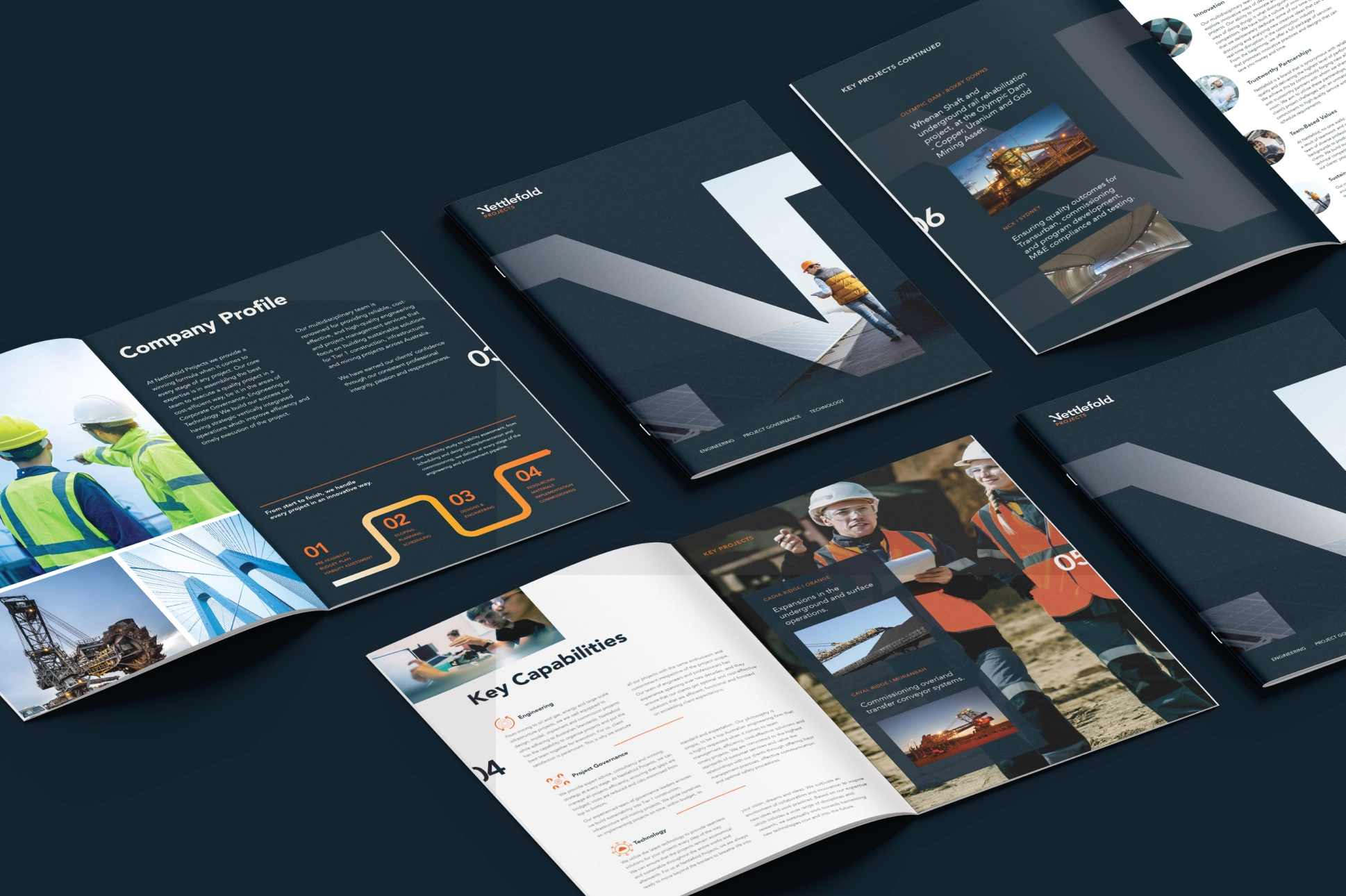 Assorted corporate brochure layouts spread out, showcasing different design and content sections focusing on company information and staff profiles.